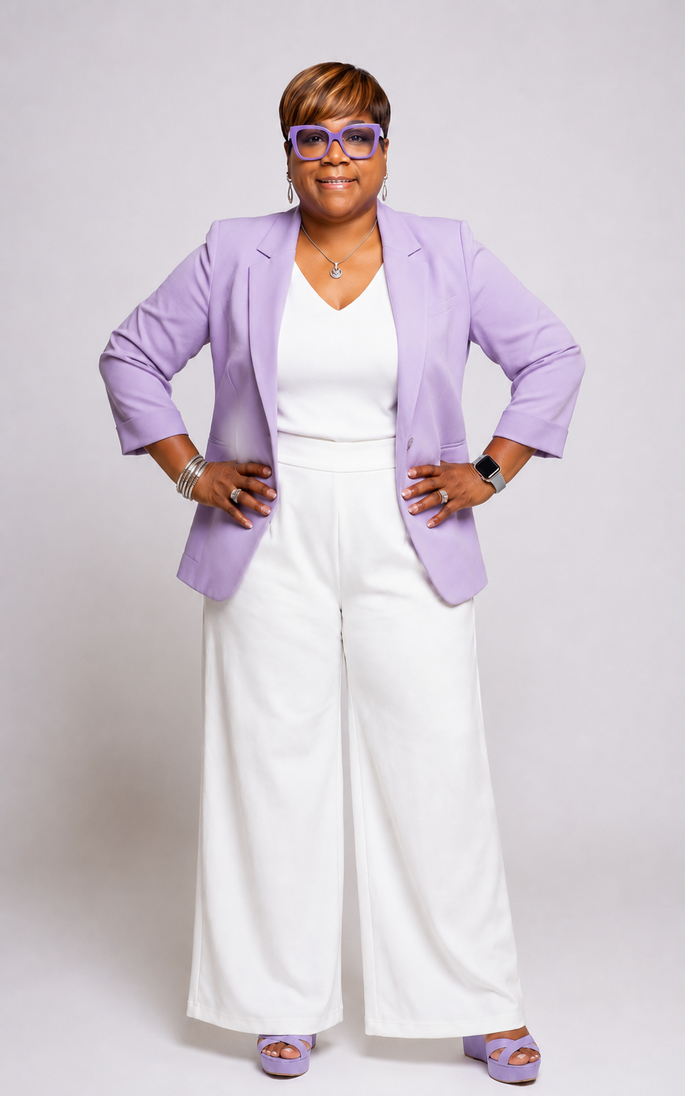 Portrait of the founder of DD Digitals in a lavender blazer and white jumpsuit.